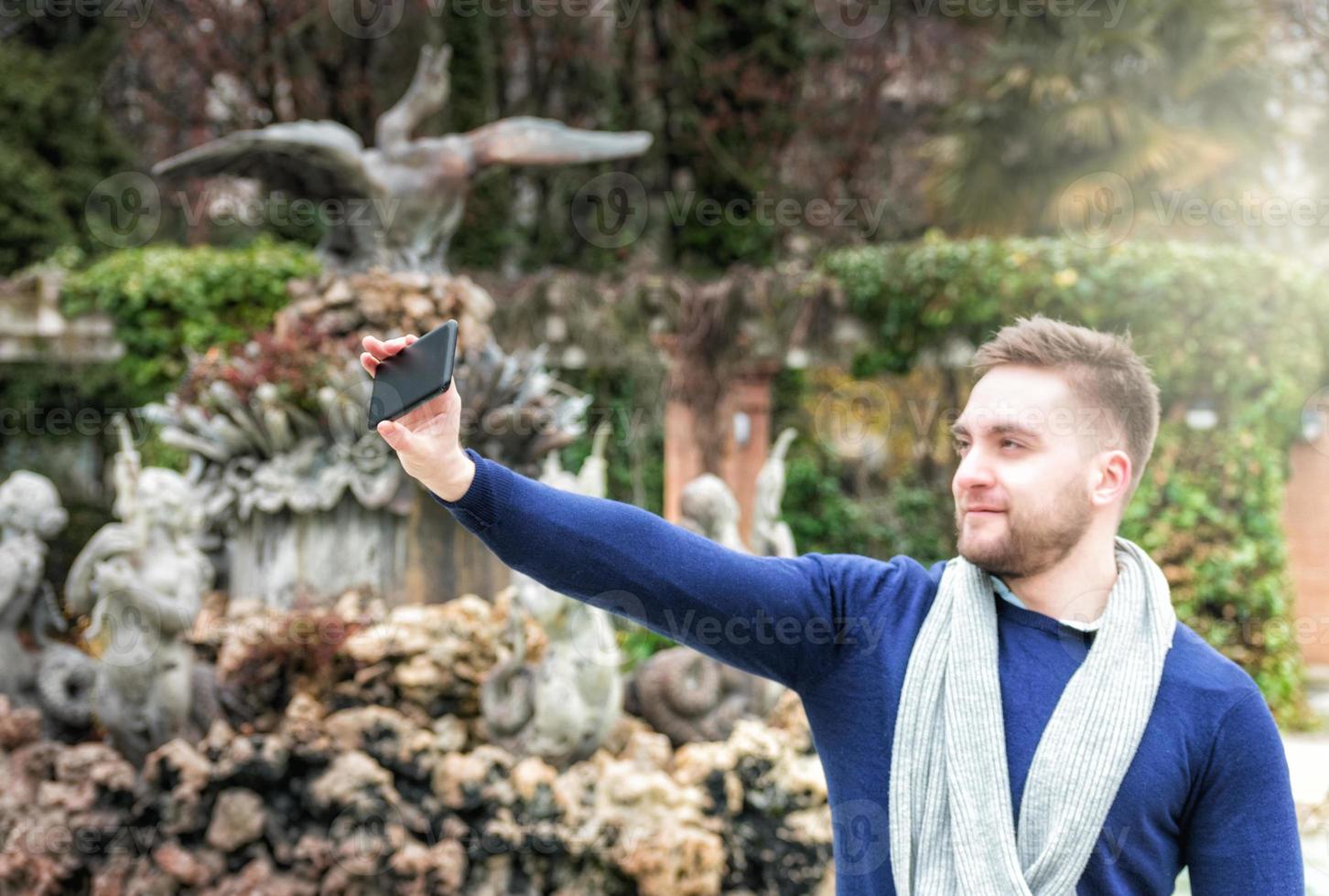 joven tomando una foto con su teléfono celular en el parque