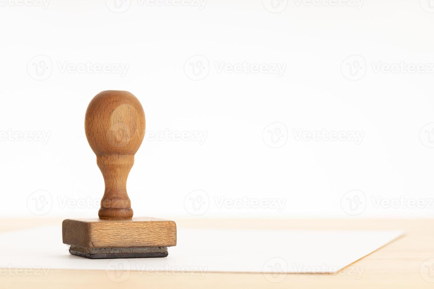Vintage rubber stamp and blank paper on wooden table photo