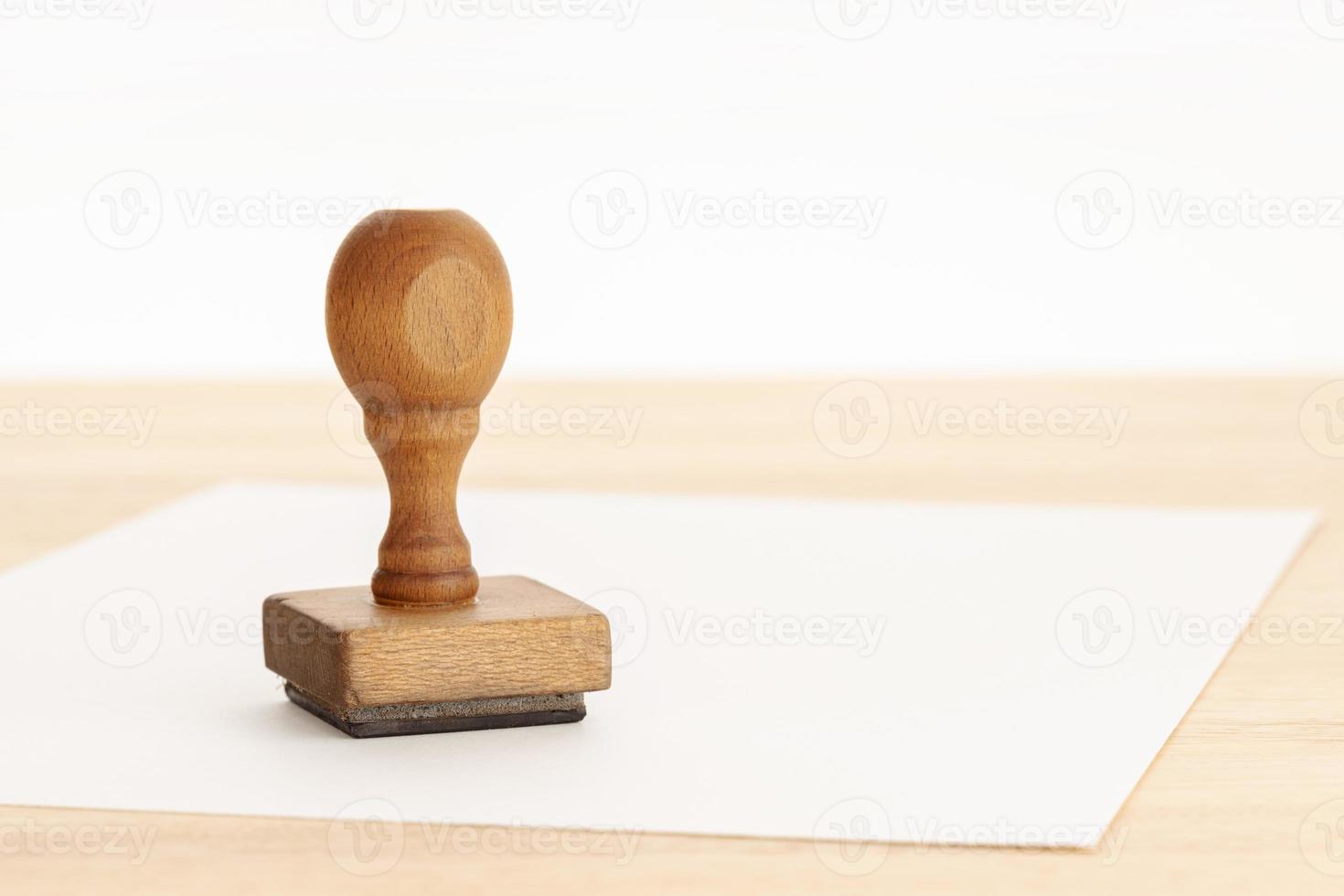 Vintage rubber stamp and blank paper on wooden table photo