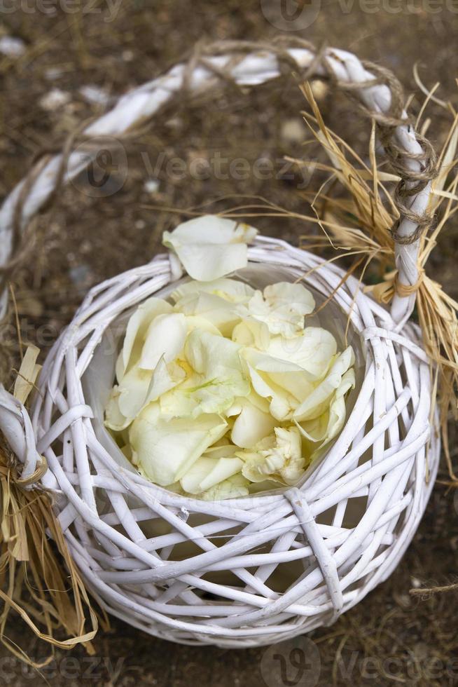 canasta de madera con pétalos de rosa blanca foto