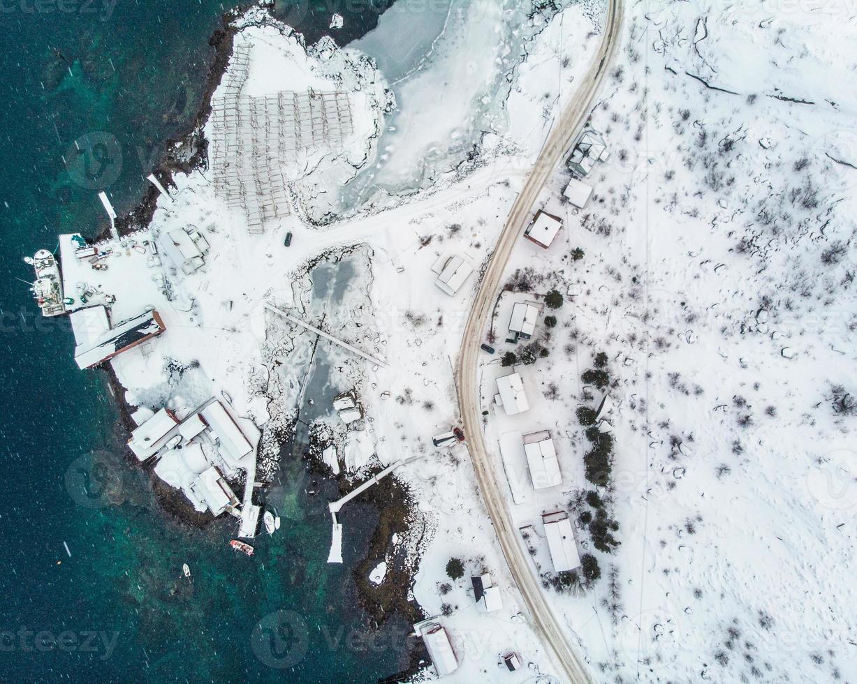 Vista aérea superior de la carretera con muelle en la costa y el océano Ártico en invierno foto