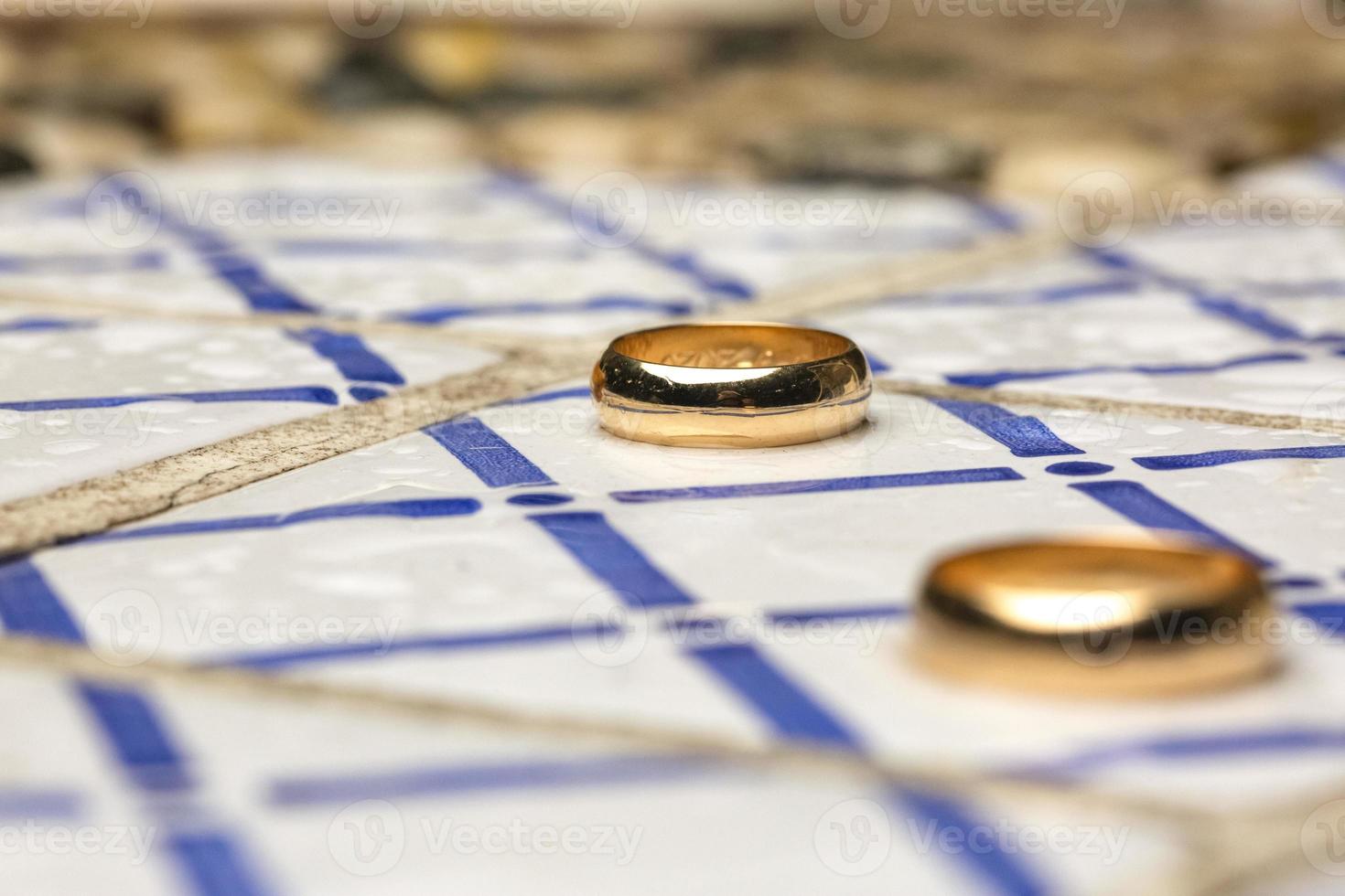 par de anillos de boda sobre azulejos decorados foto