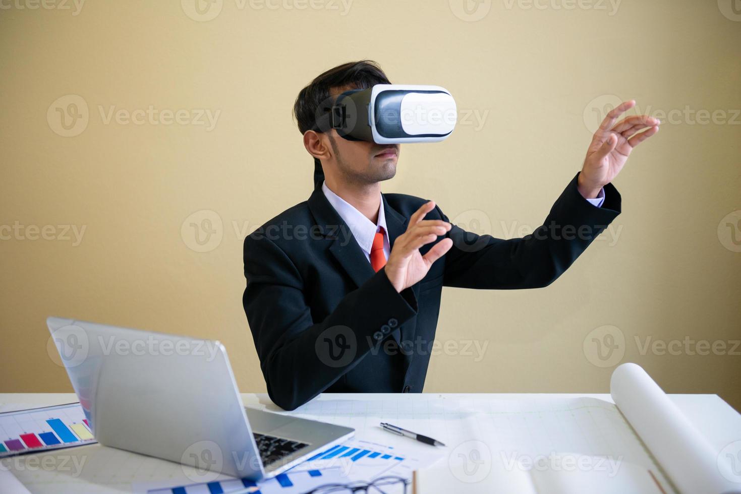 Hombre de negocios trabajando con un portátil y usando gafas de realidad virtual. foto