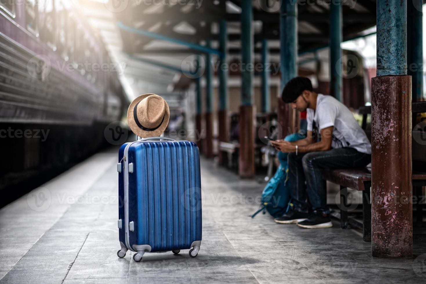 Traveler waits train at train station for travel in summer photo