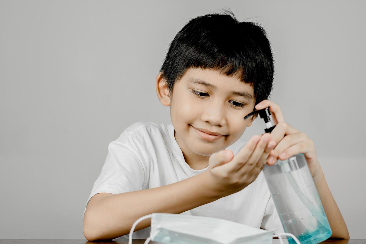 Closeup of a boy face washing his hands with alcohol gel photo