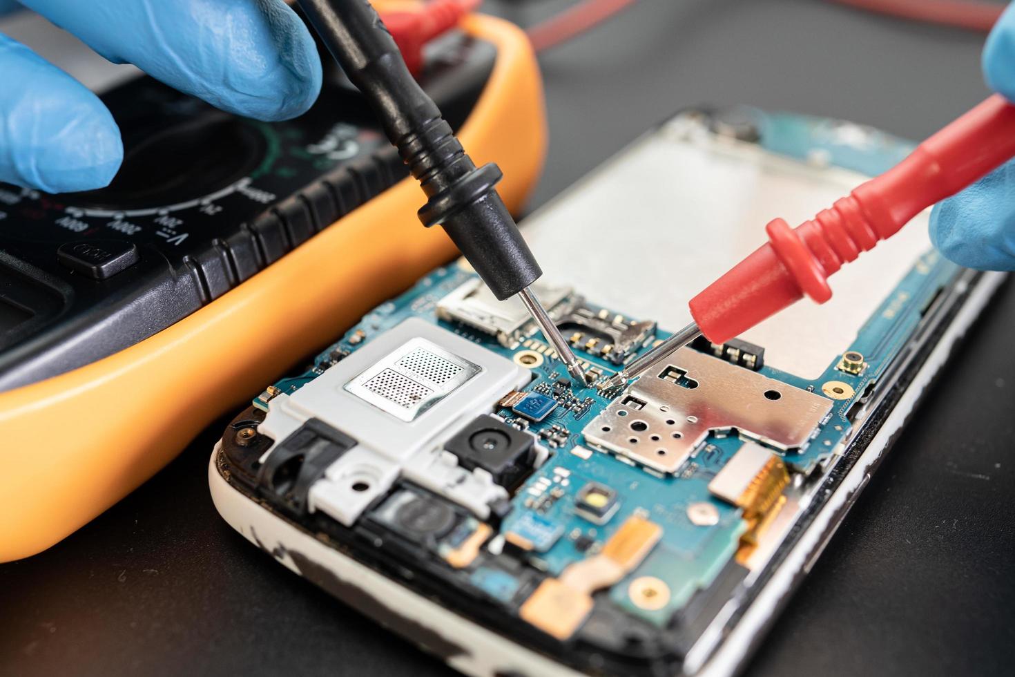 Technician repairing inside of mobile phone by soldering iron Integrated Circuit photo