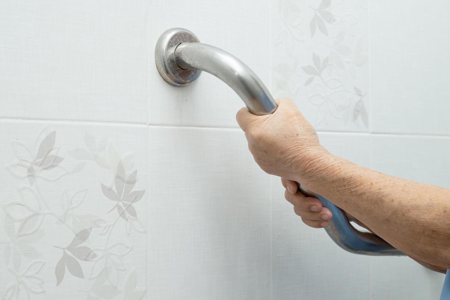 Asian senior woman patient use toilet bathroom handle security in nursing hospital ward photo