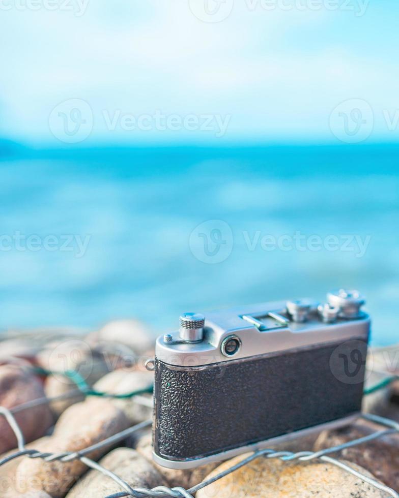 Camera on a stone fence against the sea photo