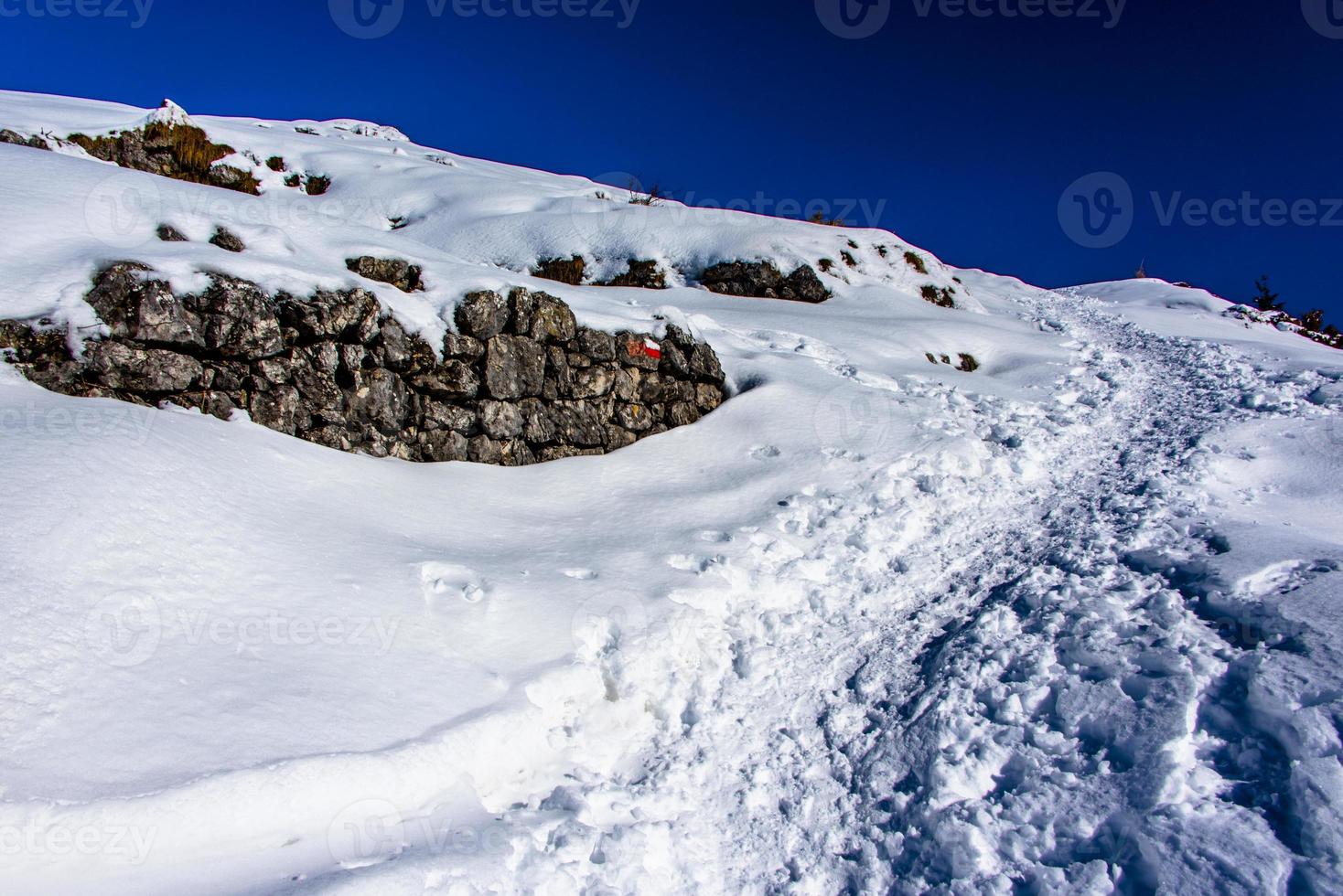 path between snow and rocks photo