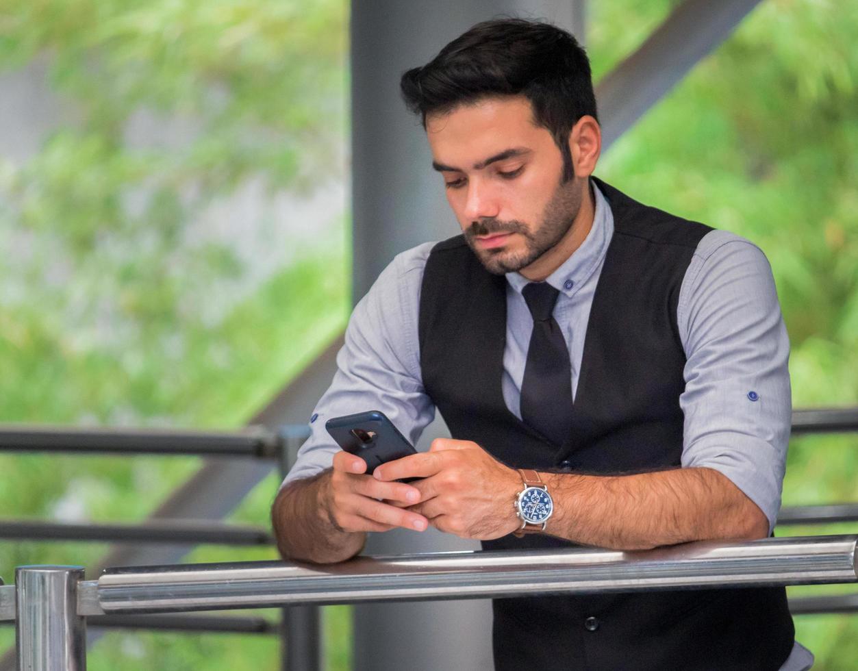 guapo, hombre de negocios, posición, en, un, smartphone foto