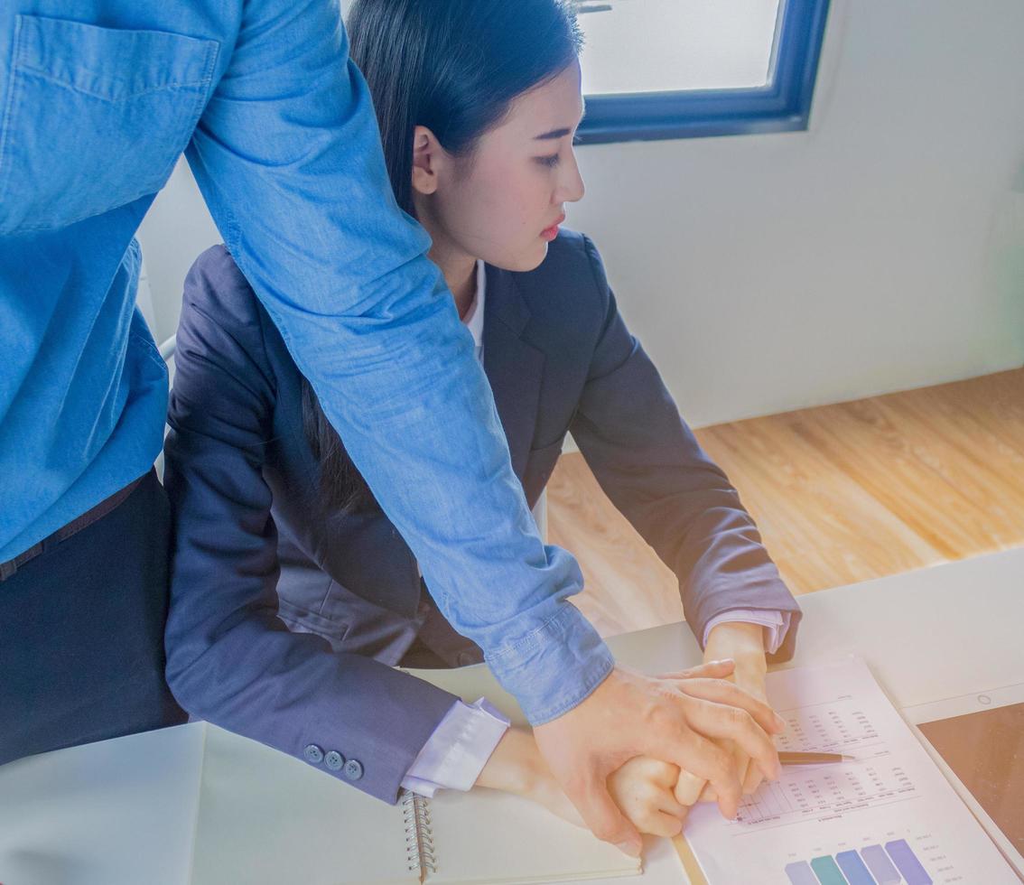 Beautiful young woman employees are sexually harassed by young employers of sexual harassment in office by holding the shoulder Portrait kick gender equality photo