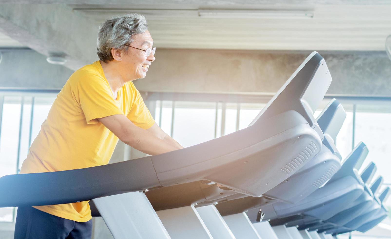 Asian elderly man exercising in the gym photo