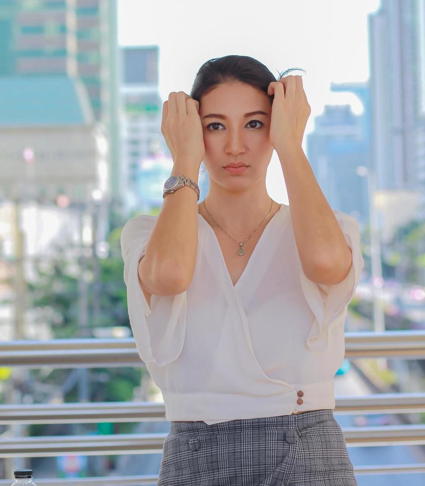 Retrato de una hermosa mujer asiática de pie en un edificio de la ciudad sonriendo felizmente estilo de vida urbano foto