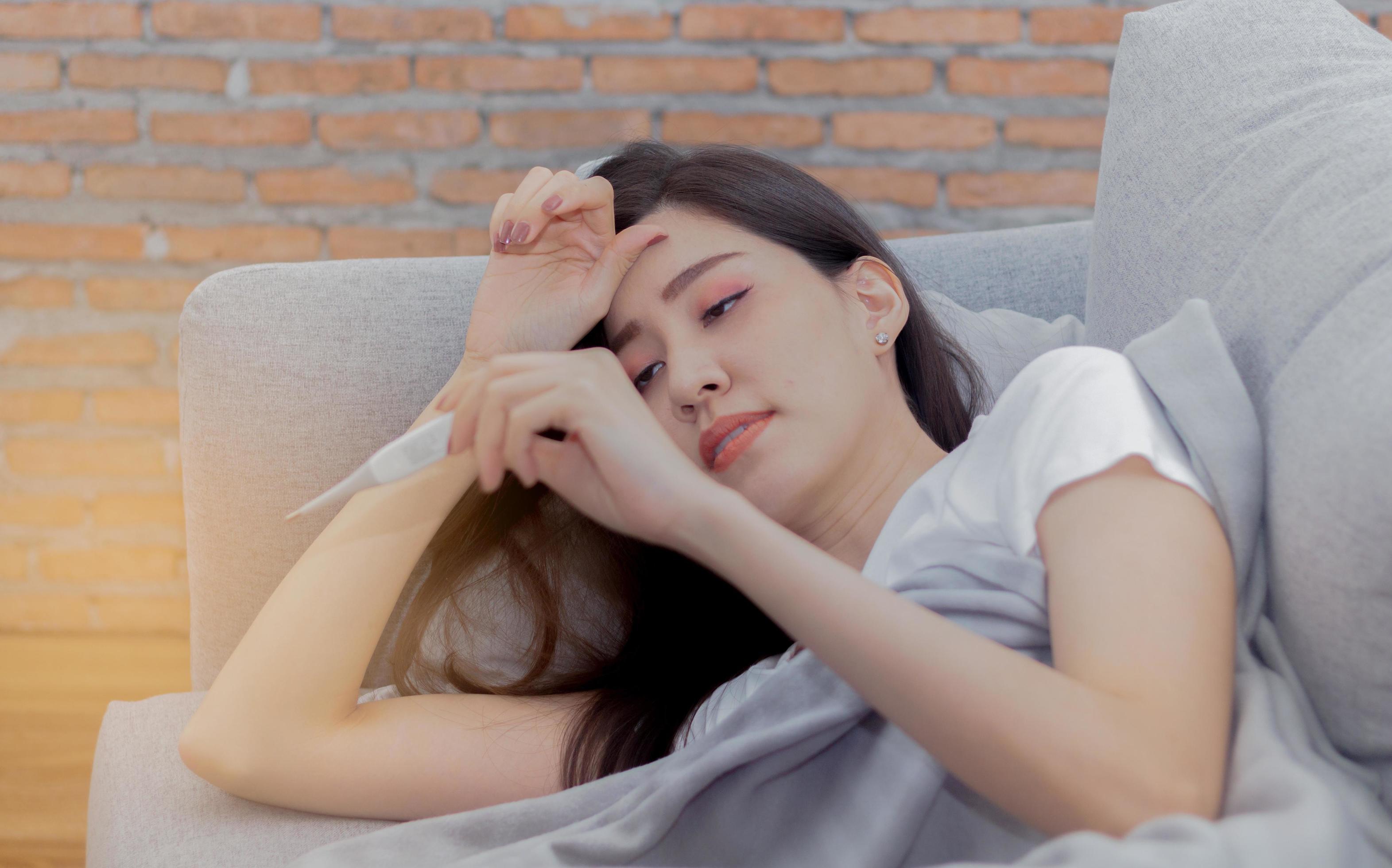 Asian woman is sick due to sickness and is holding a thermometer 2492684  Stock Photo at Vecteezy