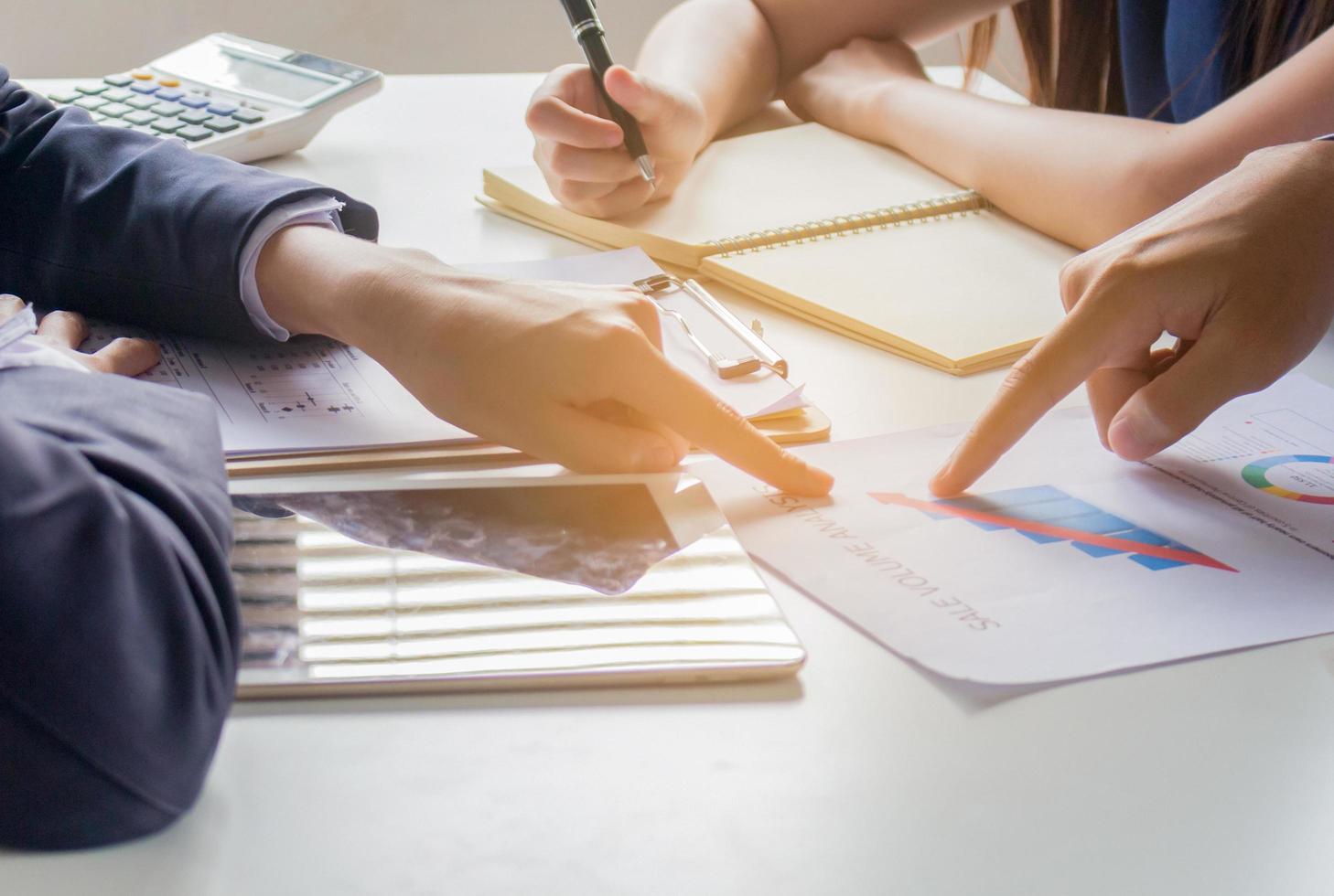 Grupo de gente de negocios se está reuniendo y viendo gráficos para el concepto de trabajo en equipo de planificación empresarial foto