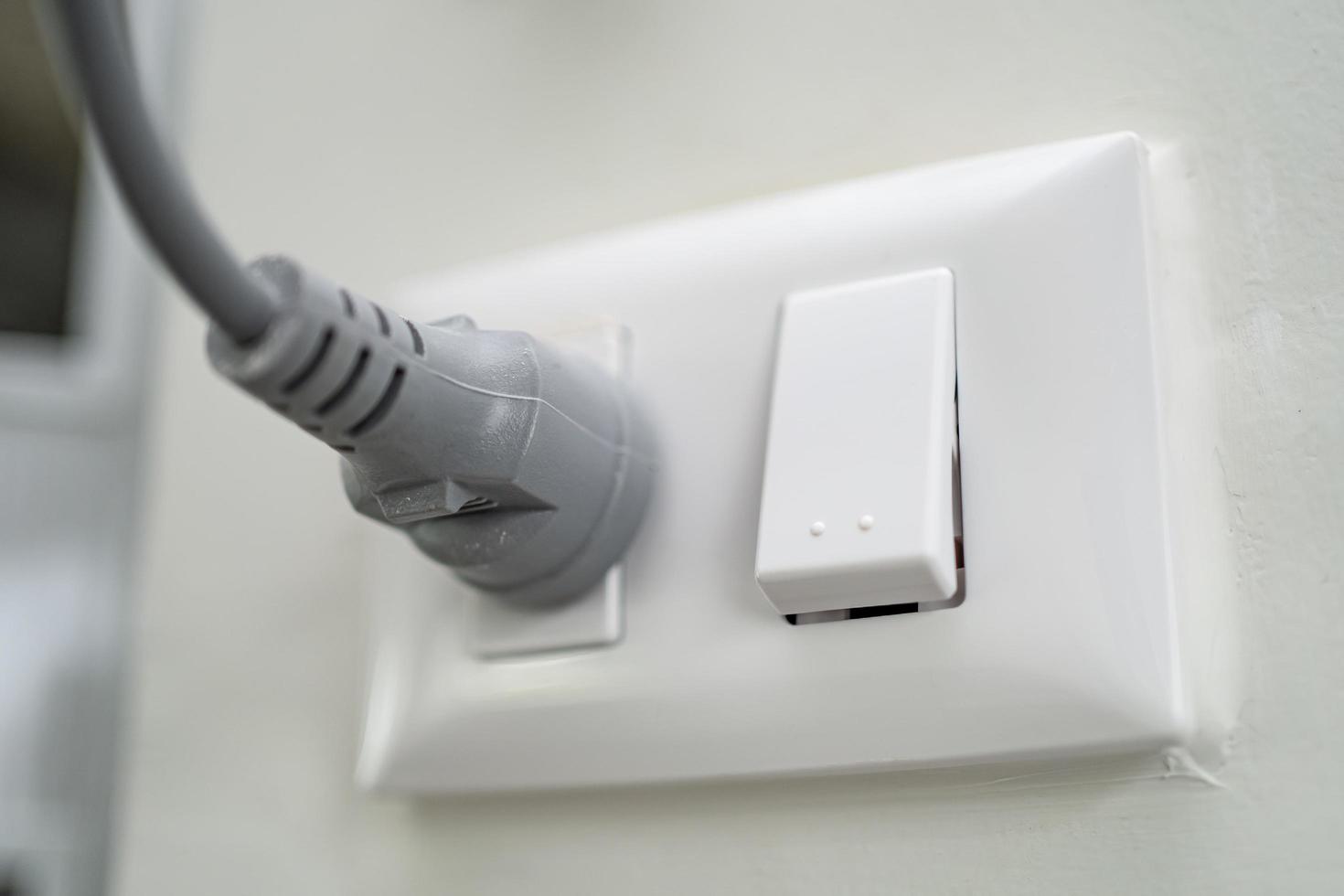 Plug electric in the socket on wall at house photo