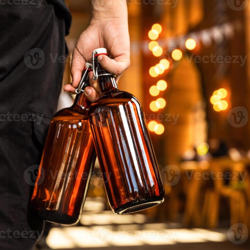 Man holding two beer glasses in on hand, back view photo