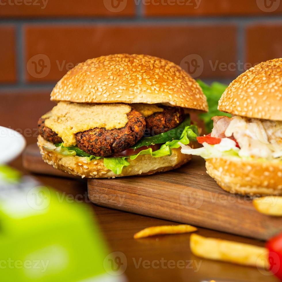 Vegetarian veggie burger with a Caesar burger on the plate photo