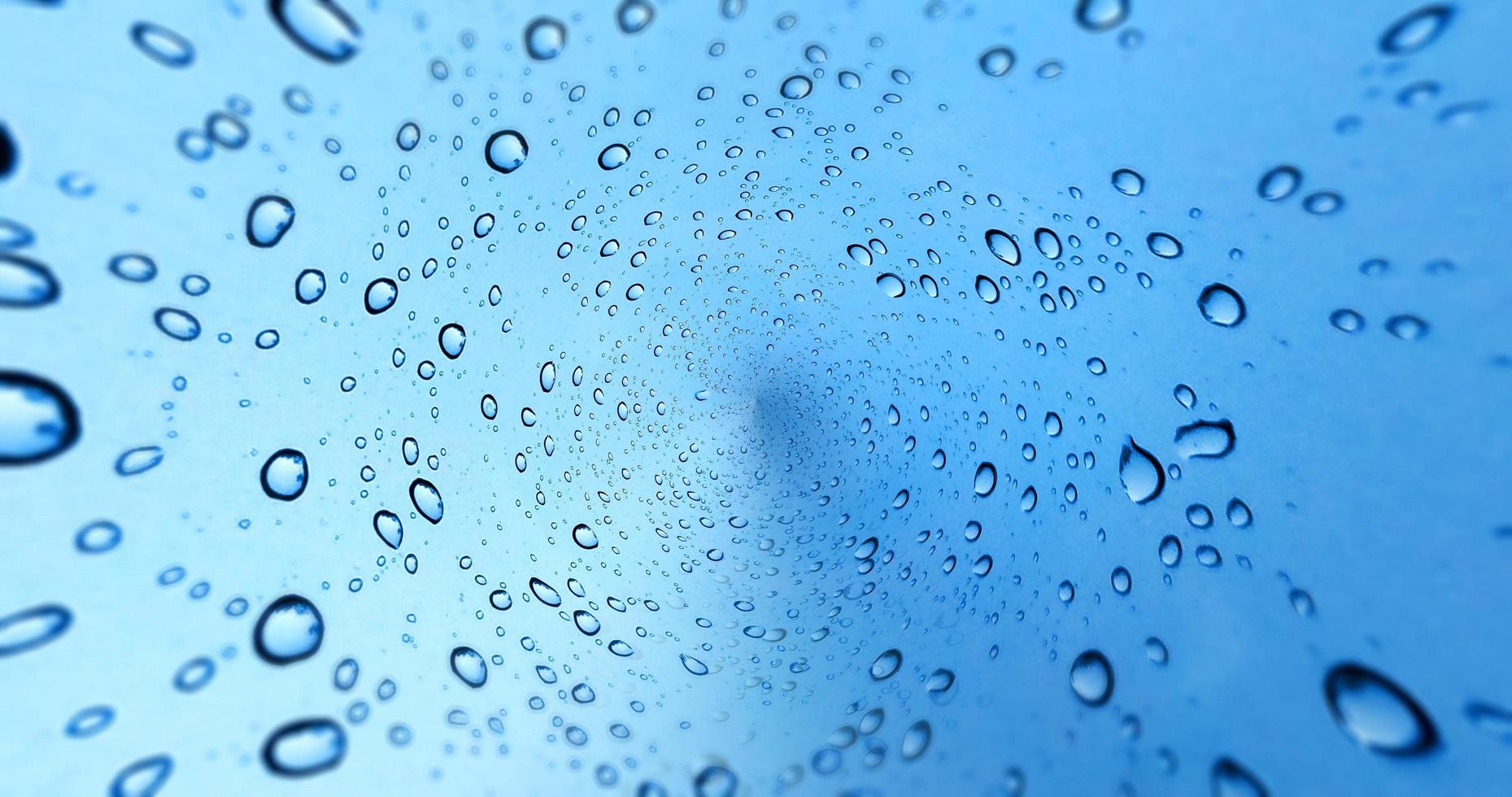 Gotas de lluvia sobre fondo de ventana de vidrio azul foto