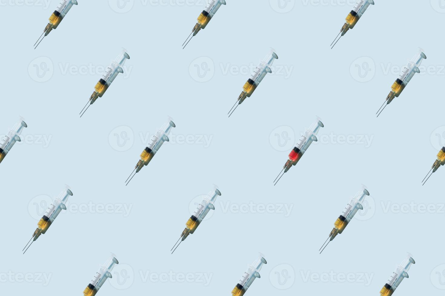 Repetitive attern made of syringes on blue background photo