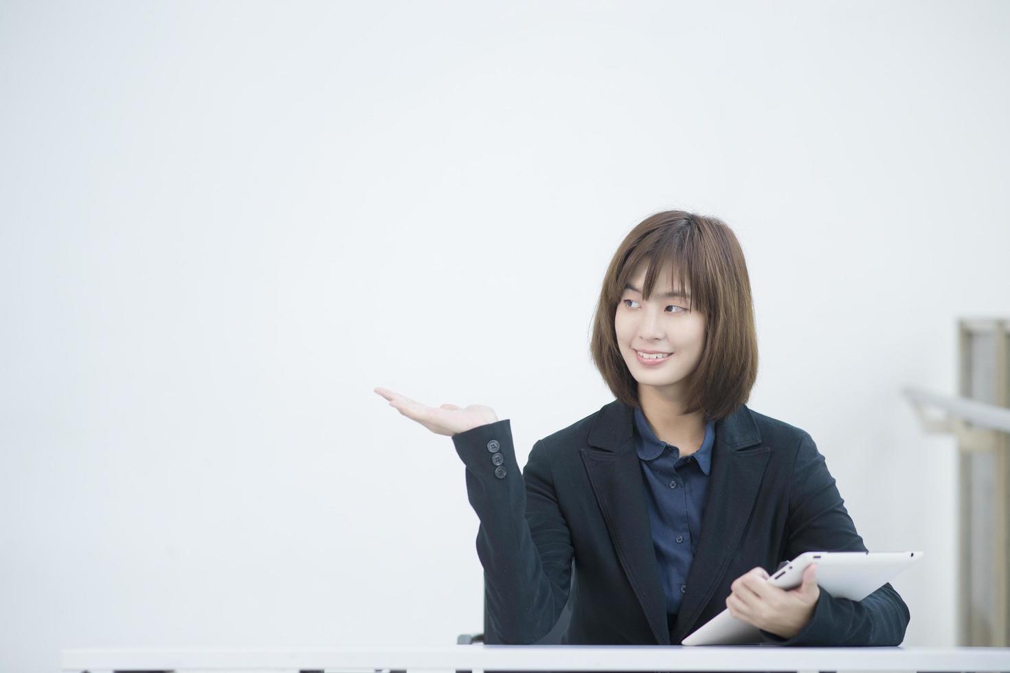 Attractive asian business woman working on tablet computer in workplace photo