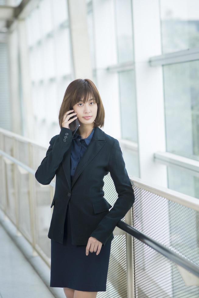 Attractive asian business woman using on smartphone outside Office photo