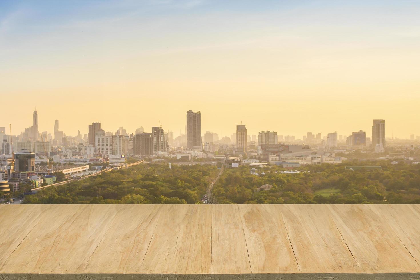 Wood floor with background of downtown city at evening photo