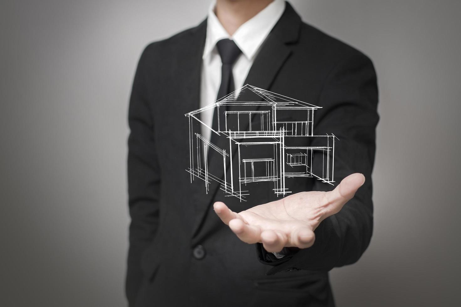 Businessman showing a model of the house photo
