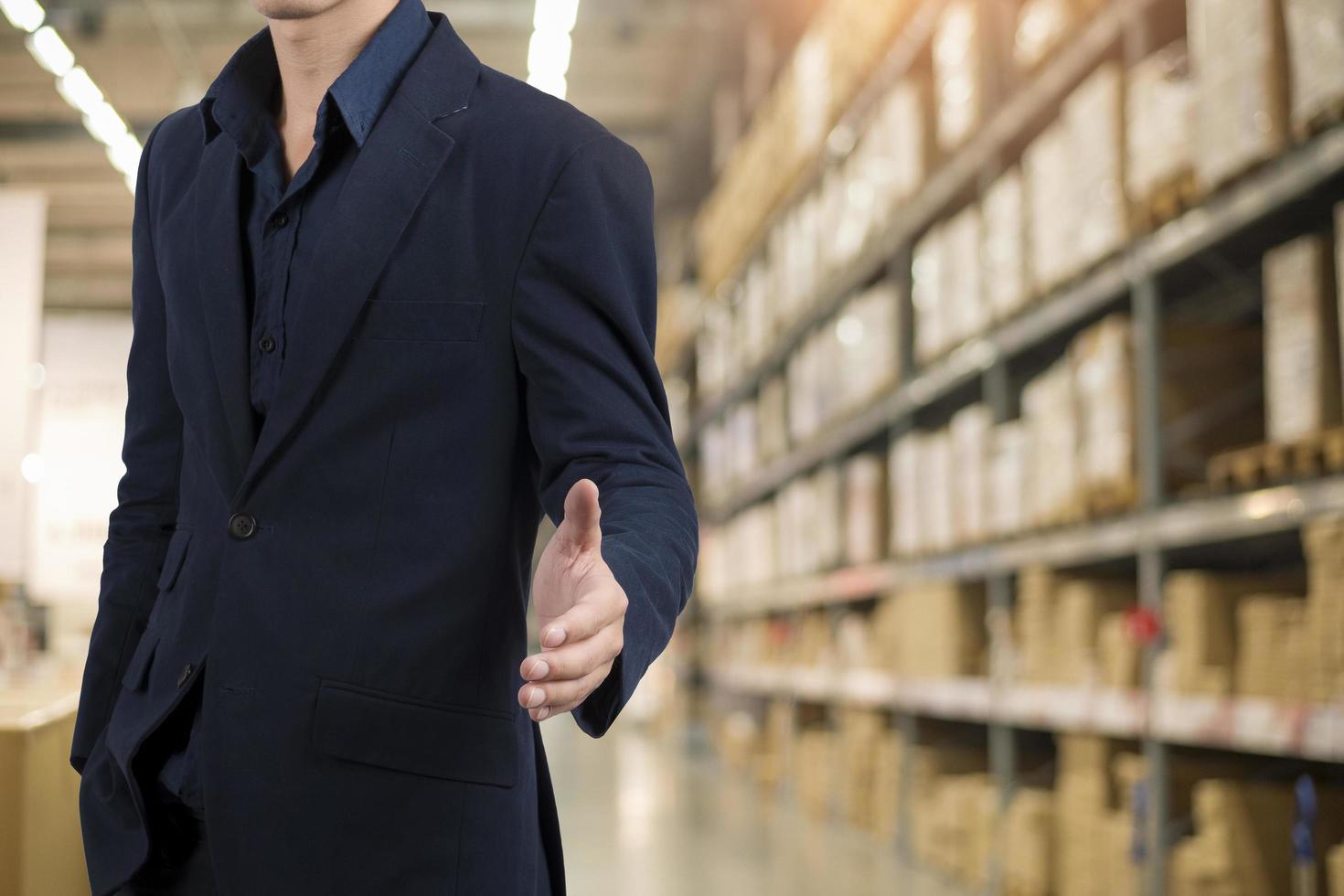 Business man in blue suit standing over warehouse background photo