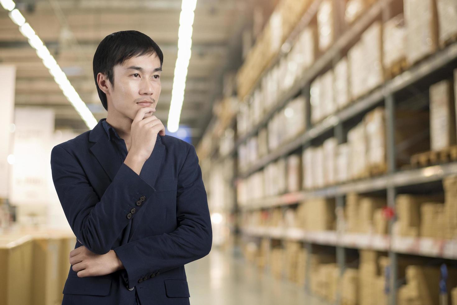 Business man in blue suit standing over warehouse background photo