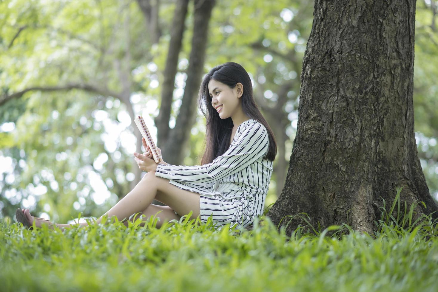 mujer atractiva leyendo un libro en el parque foto