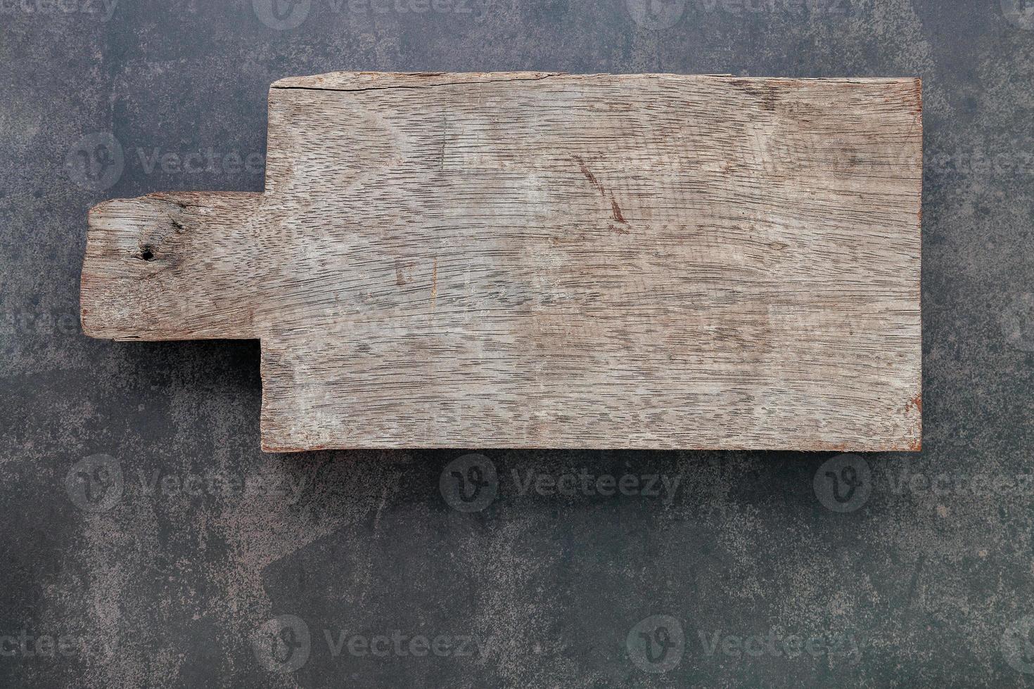 Tabla de cortar de madera vintage vacía sobre fondo de hormigón oscuro con espacio de copia foto
