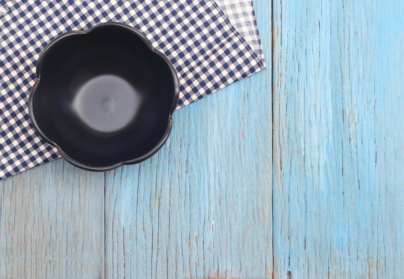 Black plate on tablecloth on wood table background photo