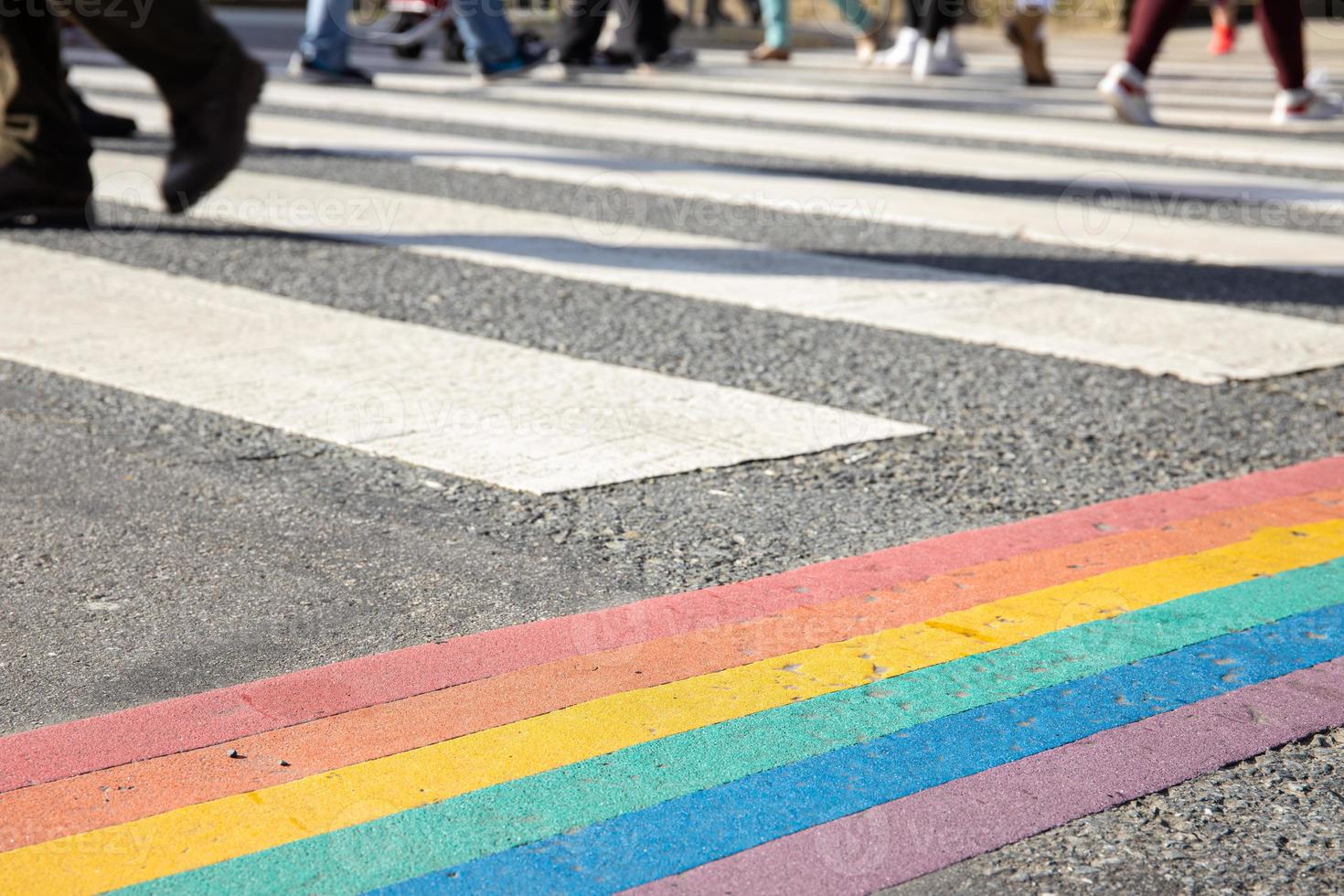 LGBTQ pride flag painted on asphalt city crosswalk photo