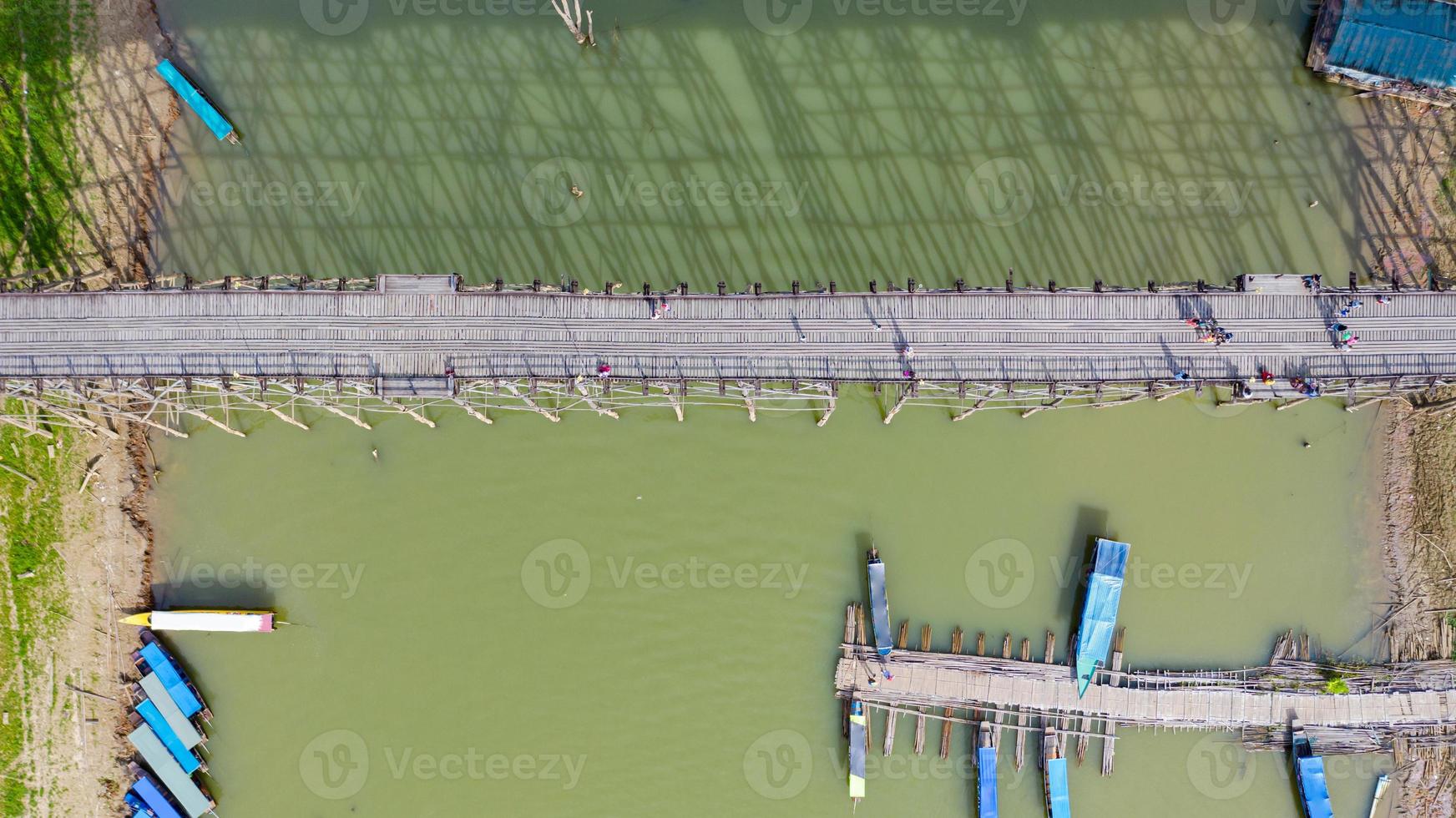 Vista aérea superior del puente de madera con barco turístico en Tailandia foto