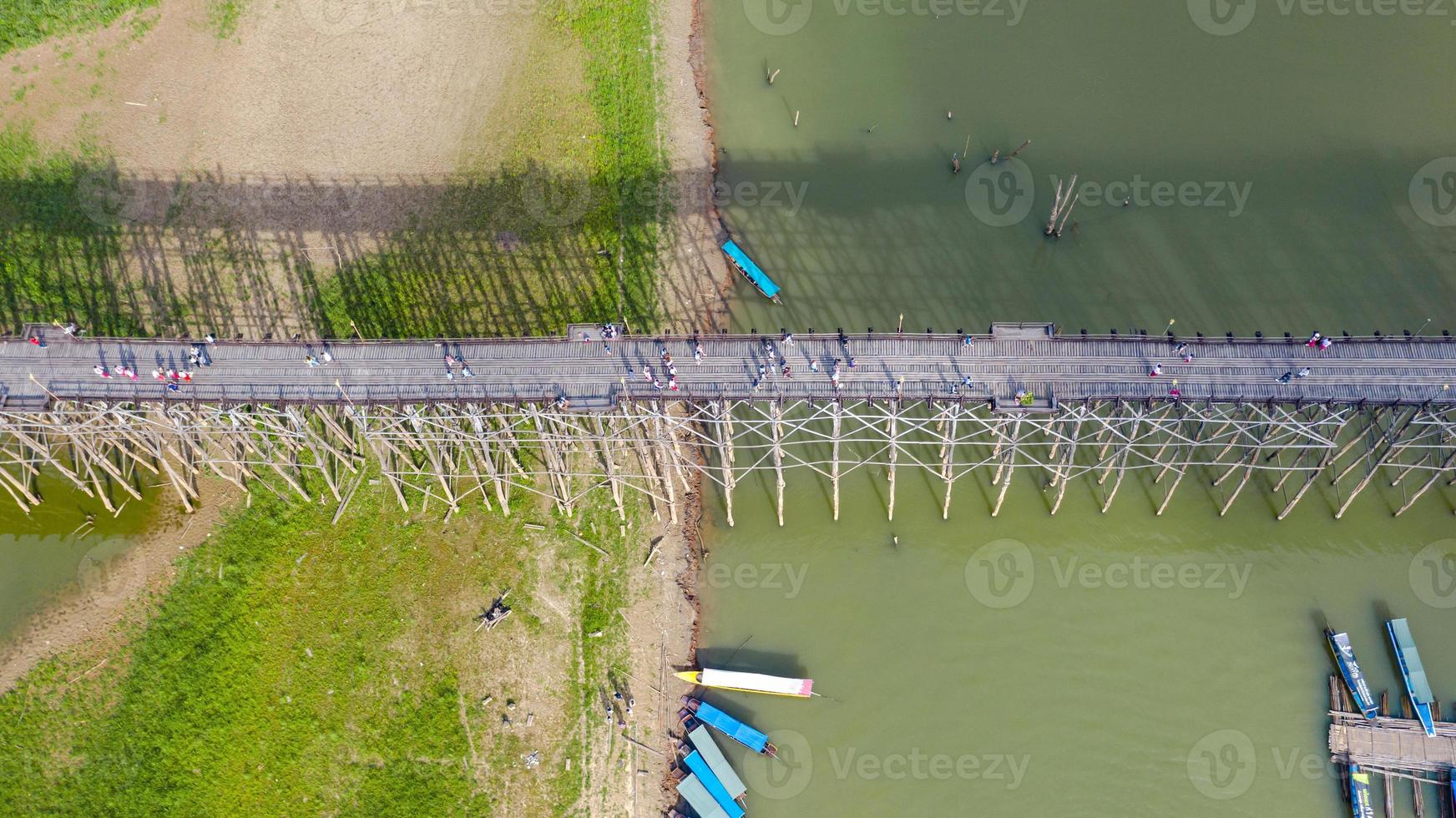 Vista aérea superior del puente de madera con barco turístico en Tailandia foto