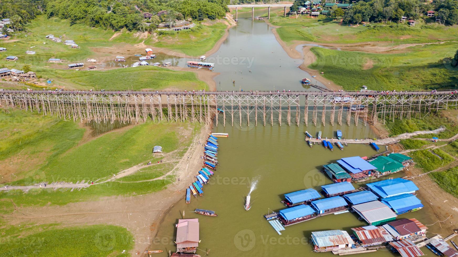 Vista aérea superior del puente de madera con barco turístico en Tailandia foto