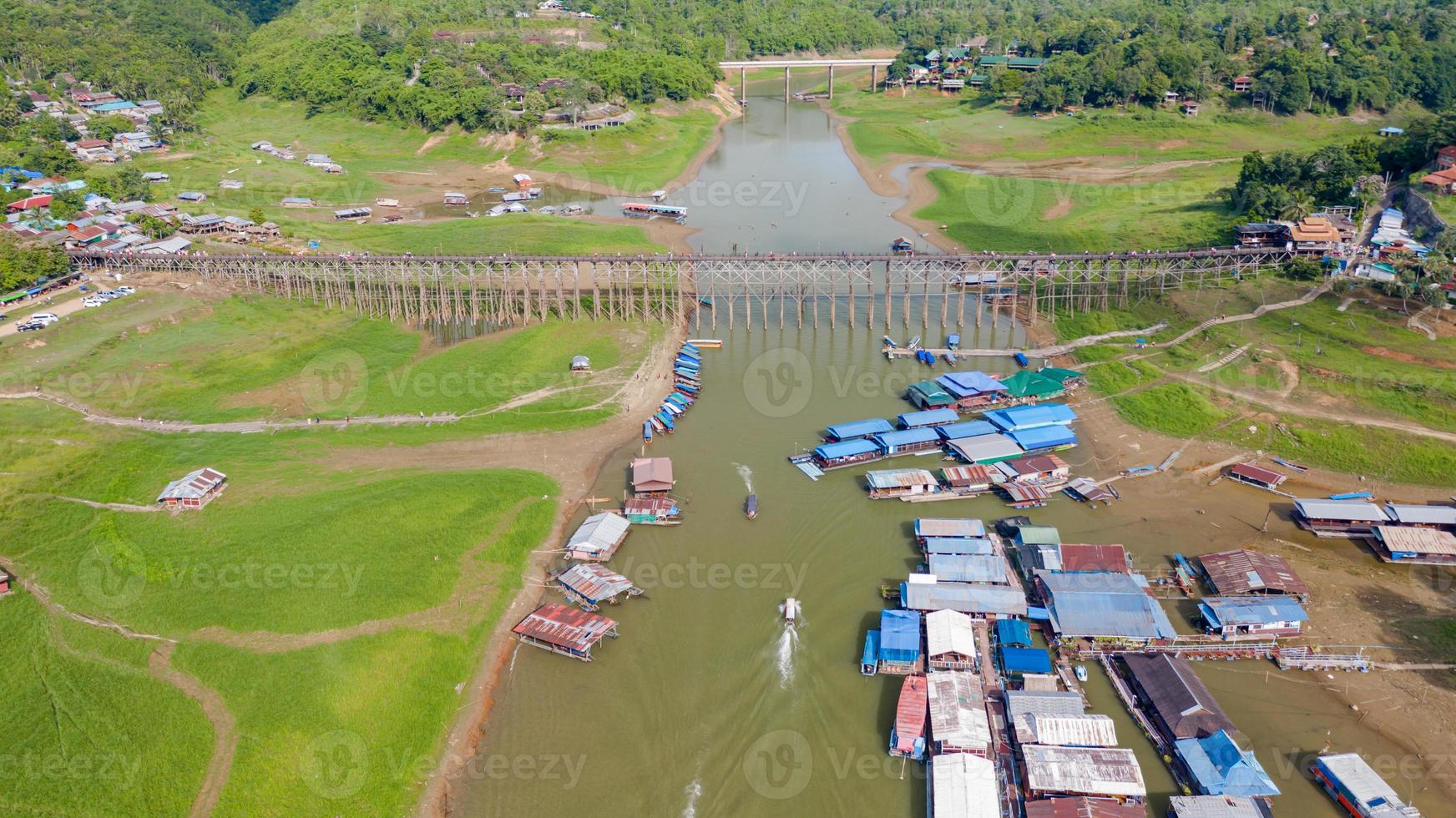 Vista aérea superior del puente de madera con barco turístico en Tailandia foto