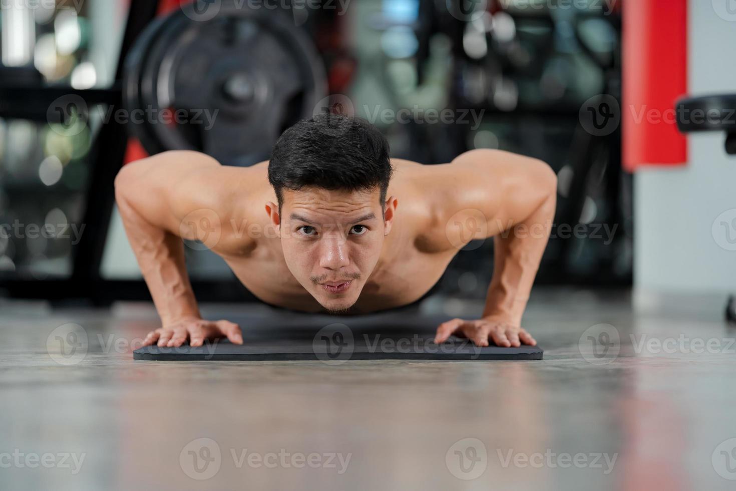 Sport man training doing push ups exercise in fitness gym photo