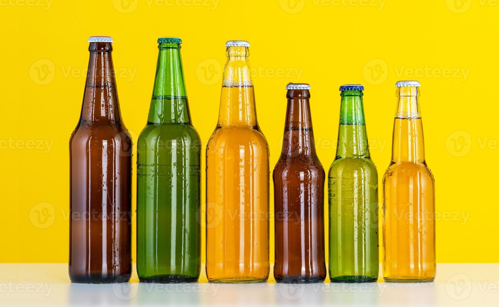 seis botellas de cerveza sobre un fondo amarillo foto