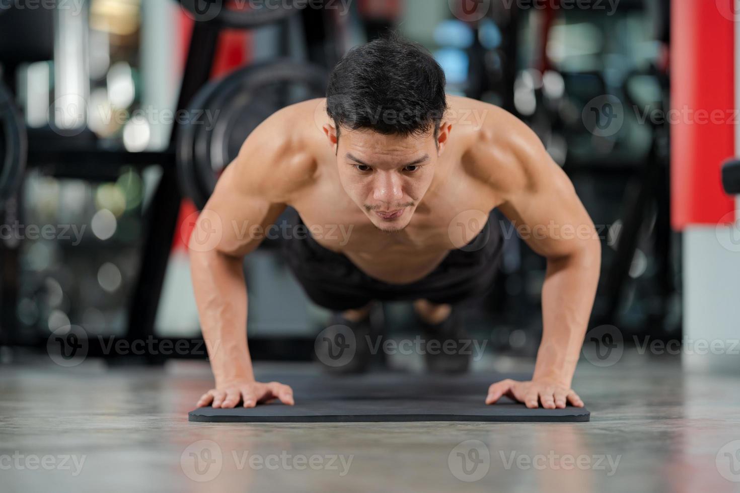 Sport man training doing push ups exercise in fitness gym photo