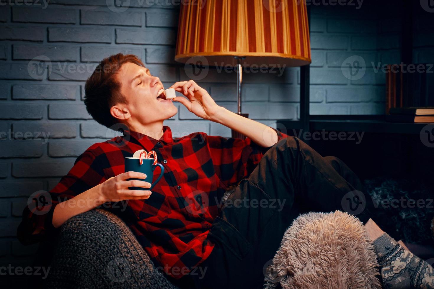 Handsome man in chair eating marshmallows photo