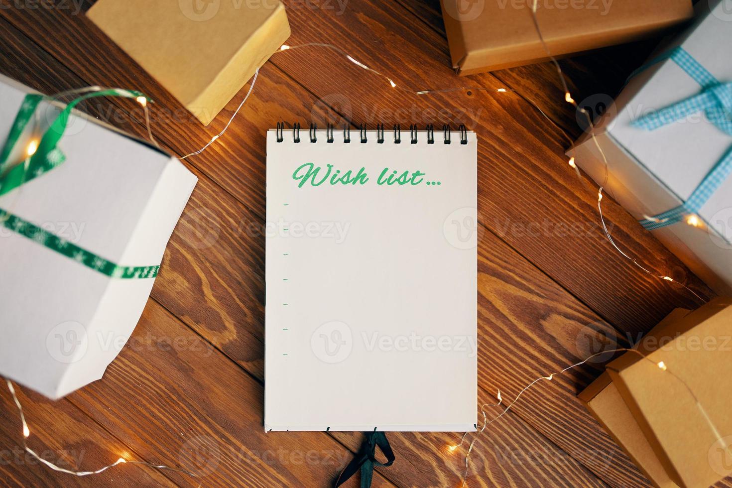 mesa de madera con cajas de regalo y bloc de notas foto