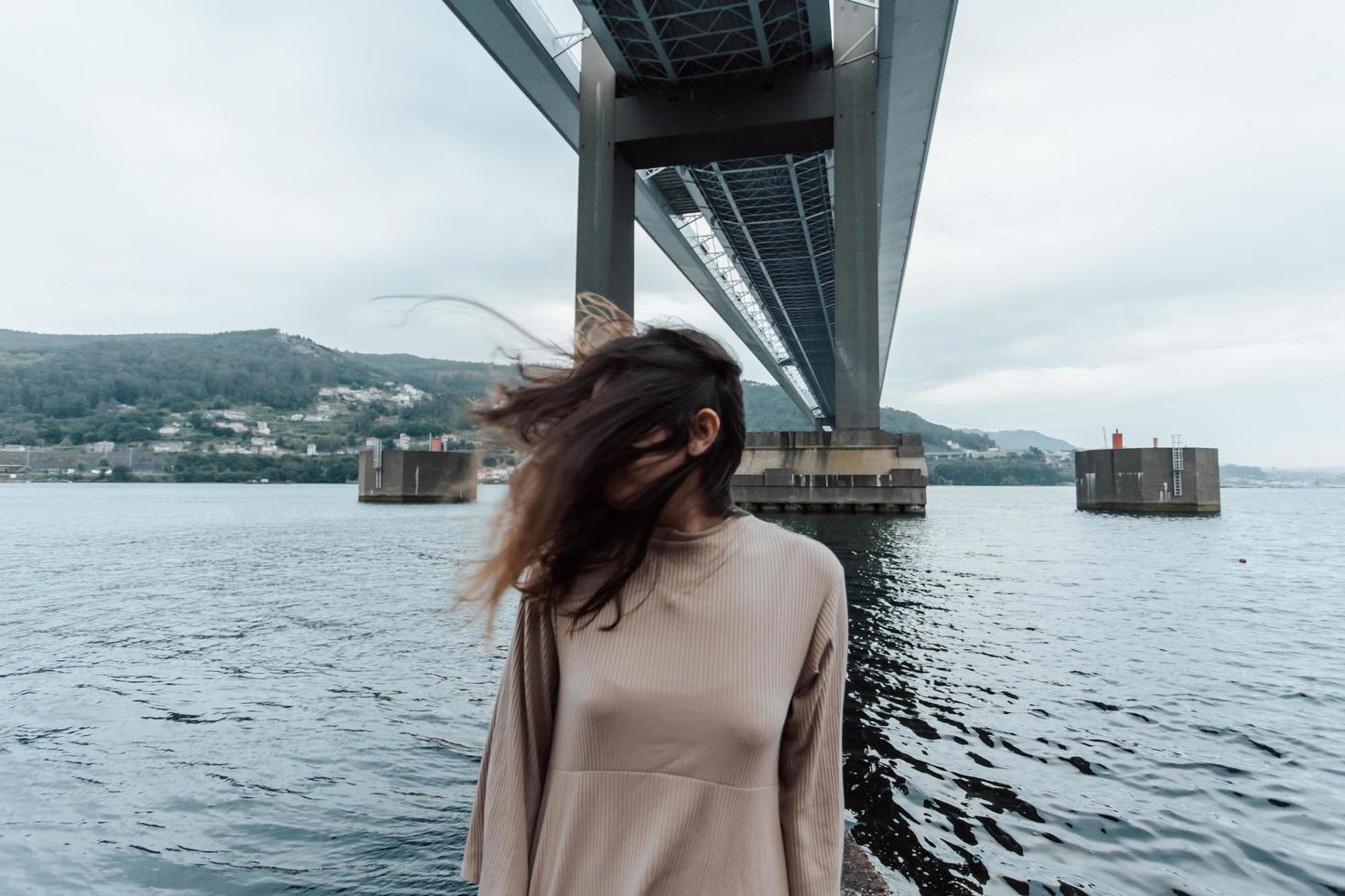 Retrato de una mujer con cabello en movimiento debajo de un puente foto