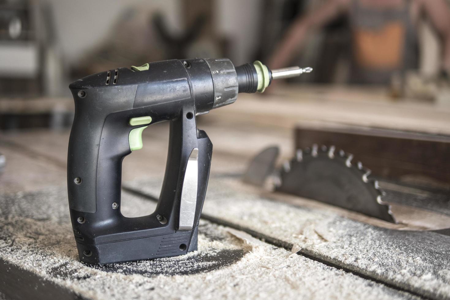 screwdriver and circular saw in sawdust joiner workshop photo