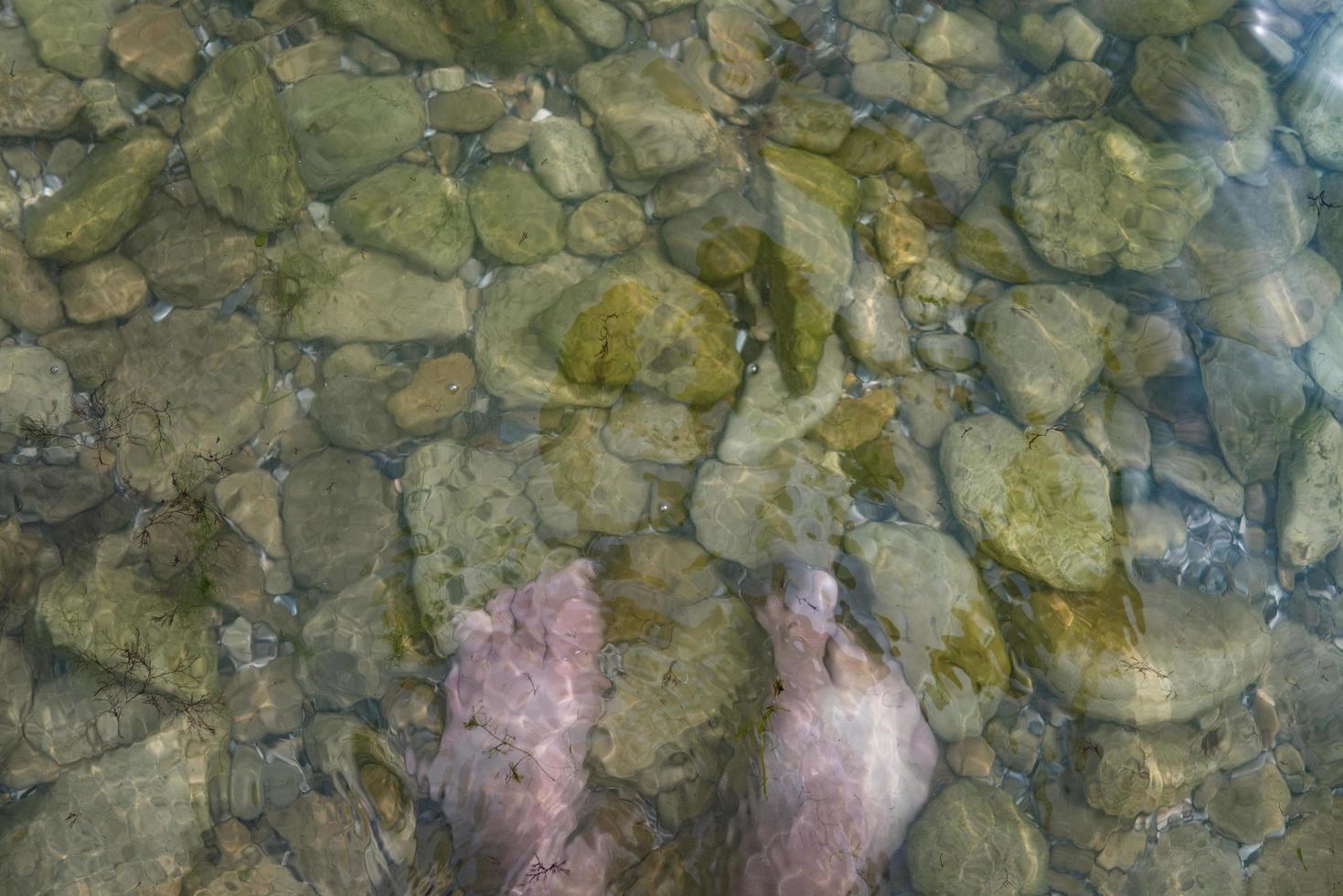 vacation at sea feet on stones in water photo