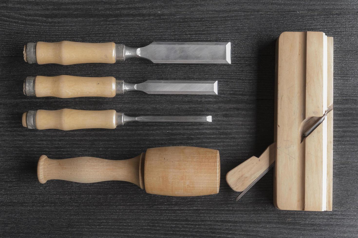 chisels and wooden mallet and plane on a black background joiner workshop photo