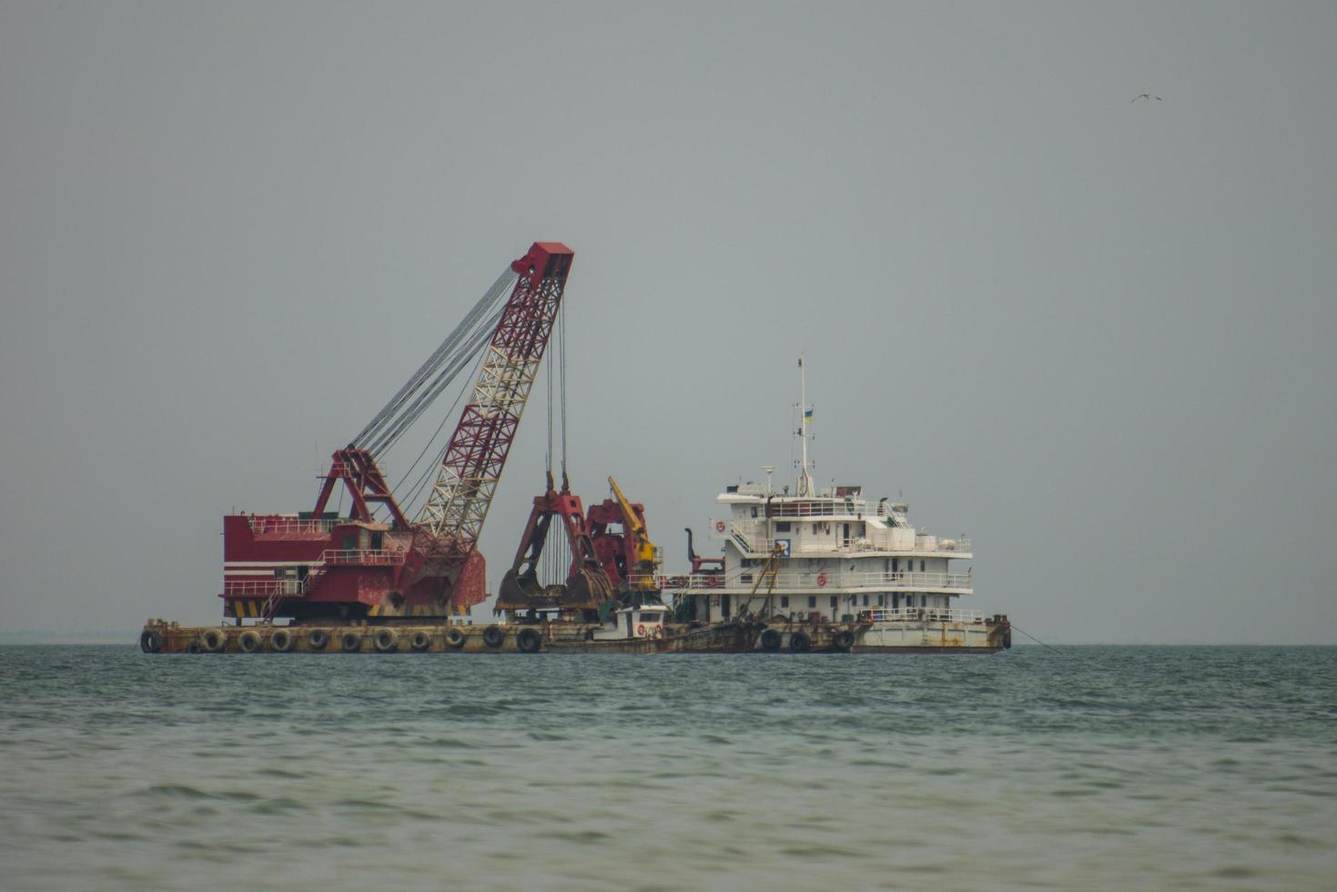 La grúa flotante y el buque de carga están trabajando en el mar. foto