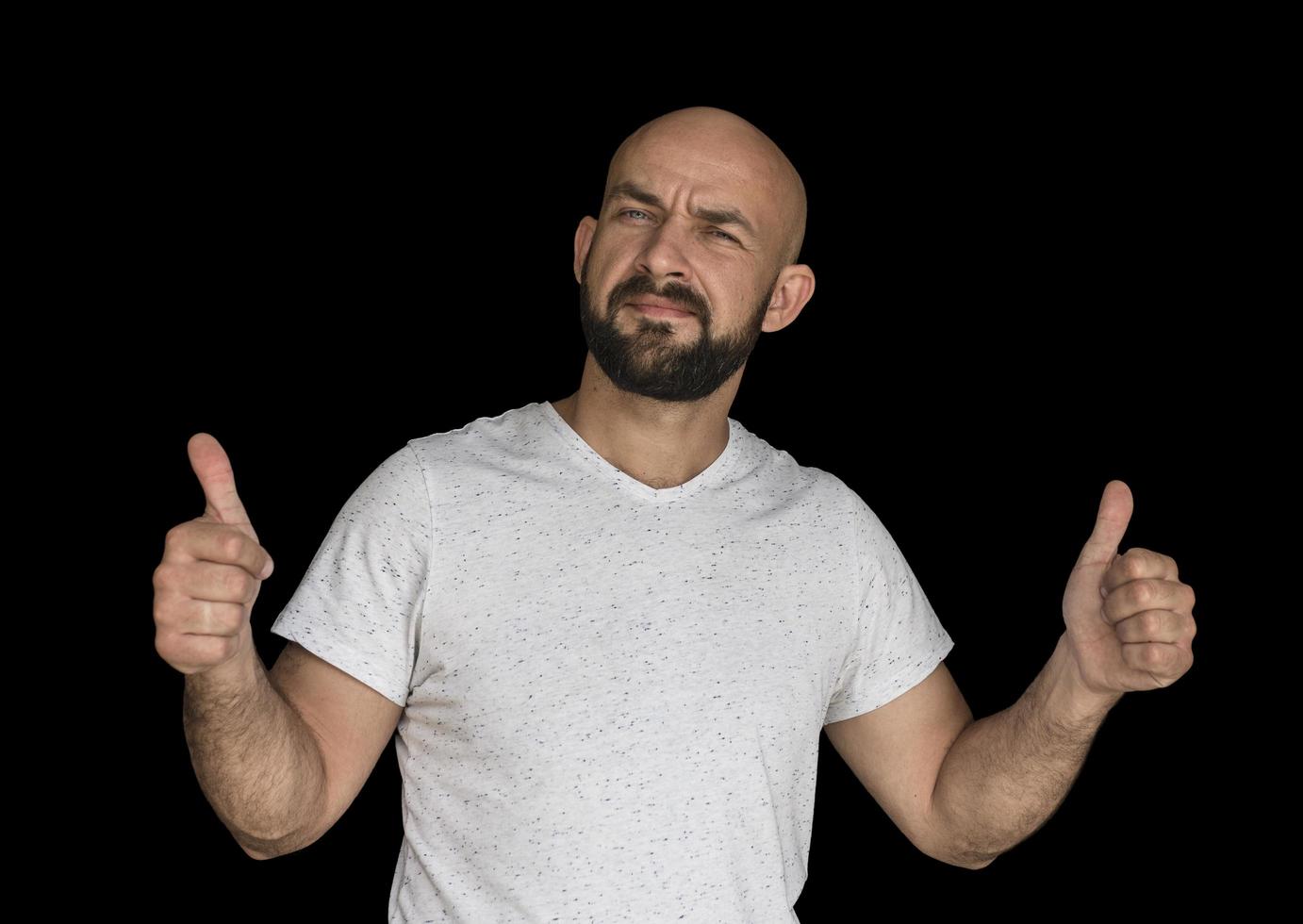 white bald man with a beard in a white T shirt keeps fingers up photo