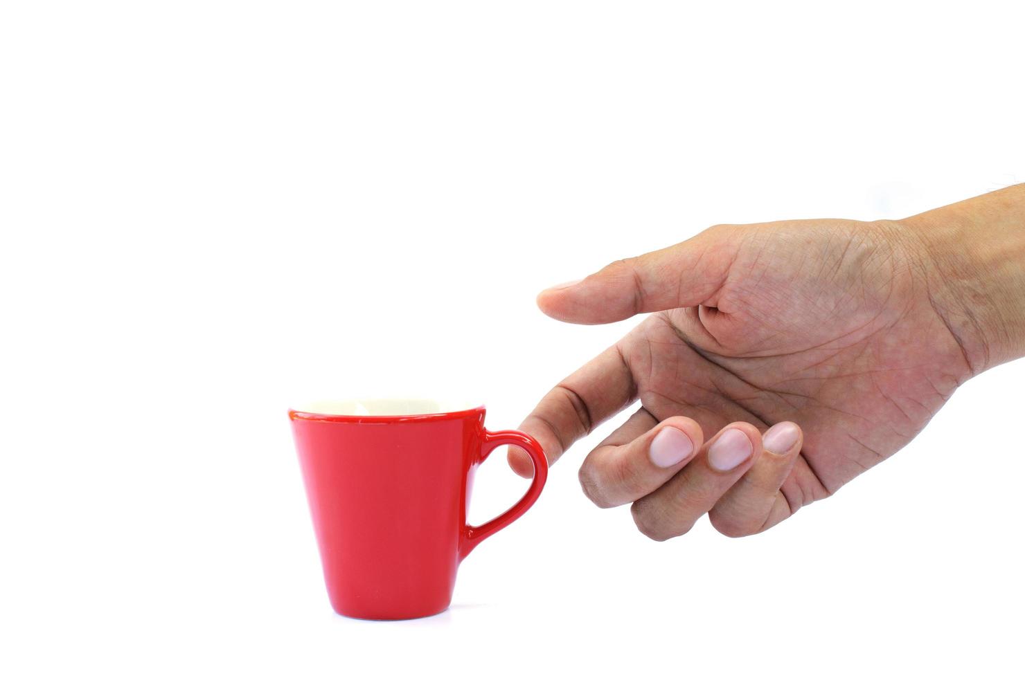 Hand holding small red cup on white background photo